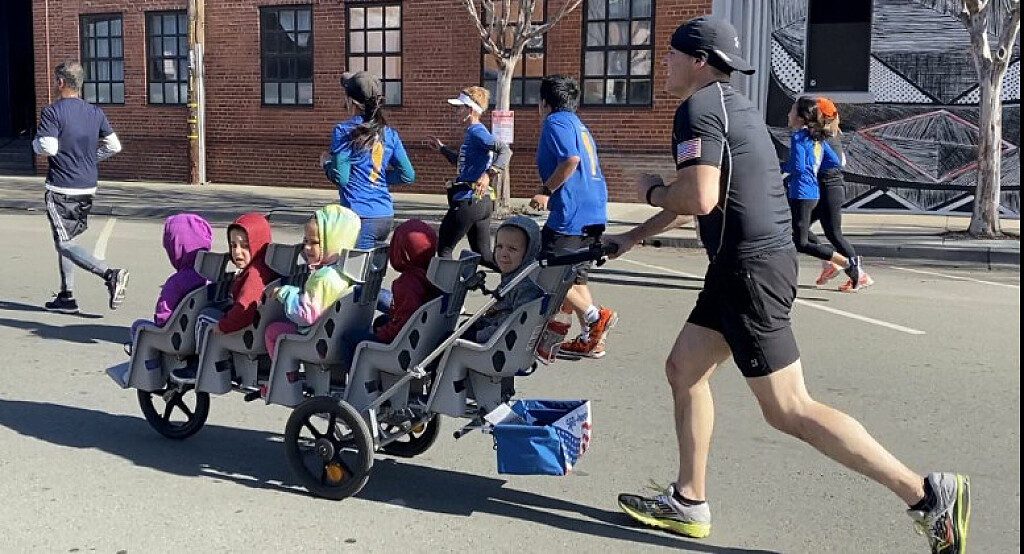 Padre di cinque gemelli spinge un passeggino unico e corre una Mezza Maratona da "Record"